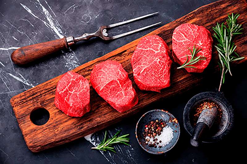 Steaks being seasoned